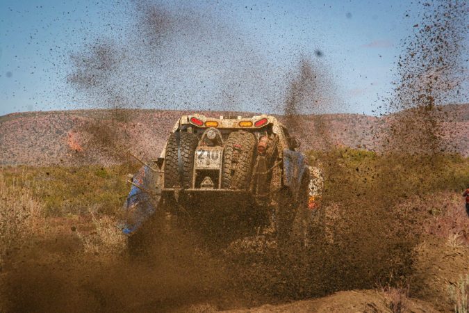 Trophy Truck racing in the deserts of Mexico - mud flying behind them